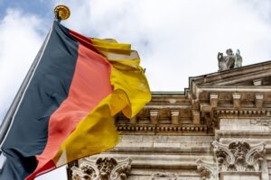 Auf der linken Seite ist die deutsche Flagge hinter einem staatlichen Gebäude